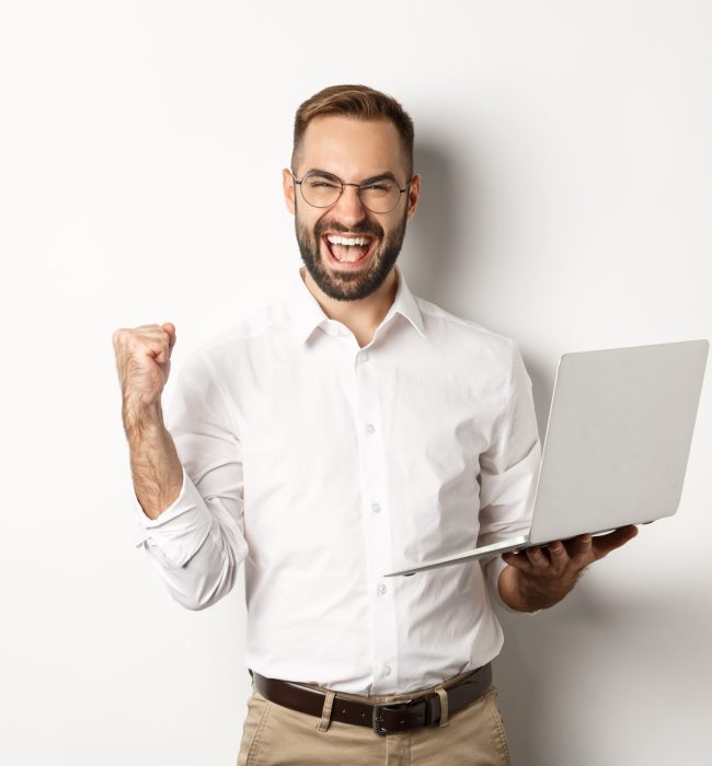business-happy-manager-winning-online-rejoicing-with-fist-pump-holding-laptop-triumphing-standing-min